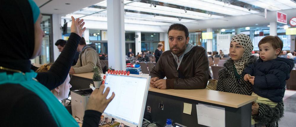 Eine Sprachmittlerin hilft in der Registrierungsstelle für Flüchtlinge in Berlin einer Familie aus Syrien bei der Orientierung im Gebäude.
