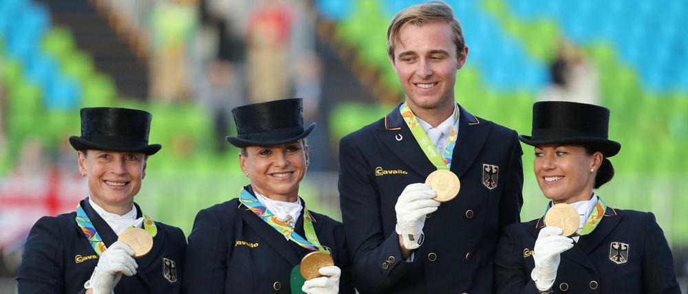 Da ist das Ding. Deutschlands Dressurreiter präsentieren stolz die Goldmedaillen. 