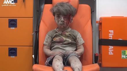 Der Videograp aus einem Handout Video der syrischen Aktivistengruppe Aleppo Media Center (AMC) vom 18.08.2016 zeigt einen vierjährigen Jungen, der am 17.08.2016 in der Stadt Aleppo (Syrien) mit blutverschmiertem Gesicht in einem Krankenwagen sitzt, nachdem ein Haus bei einem Luftangriff zerstört worden war.