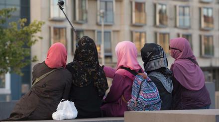 Frauen mit Kopftüchern auf einer Stele des Berliner Holocaust-Mahnmals. 