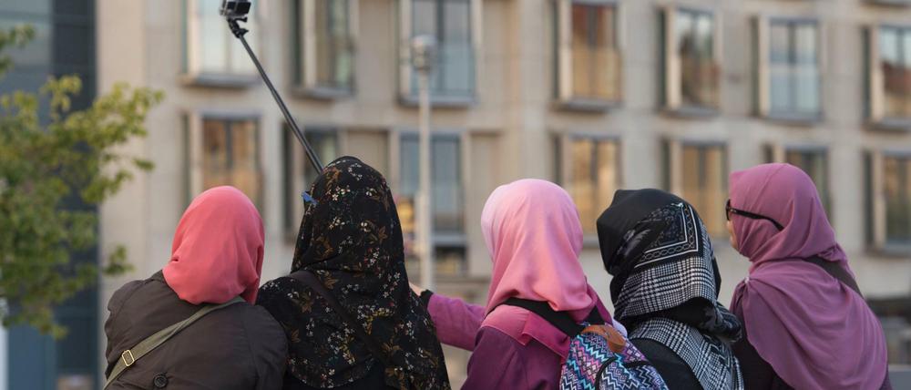 Frauen mit Kopftüchern auf einer Stele des Berliner Holocaust-Mahnmals. 