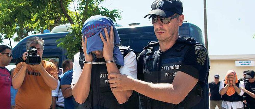 Ein türkischer Offizier, der nach Griechenland geflüchtet ist, wird von einem Polizisten zum Gericht geführt.