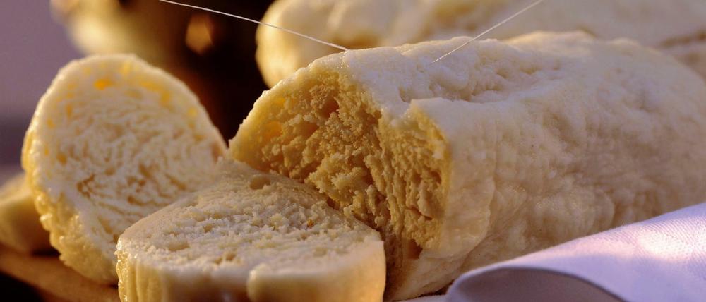 Serviettenknödel werden mit Bindfaden in Scheiben geschnitten. 