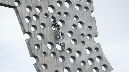 Ein Fahrrad hängt an der Skulptur "Molecule Man" des US-amerikanischen Künstlers Jonathan Borofsky.