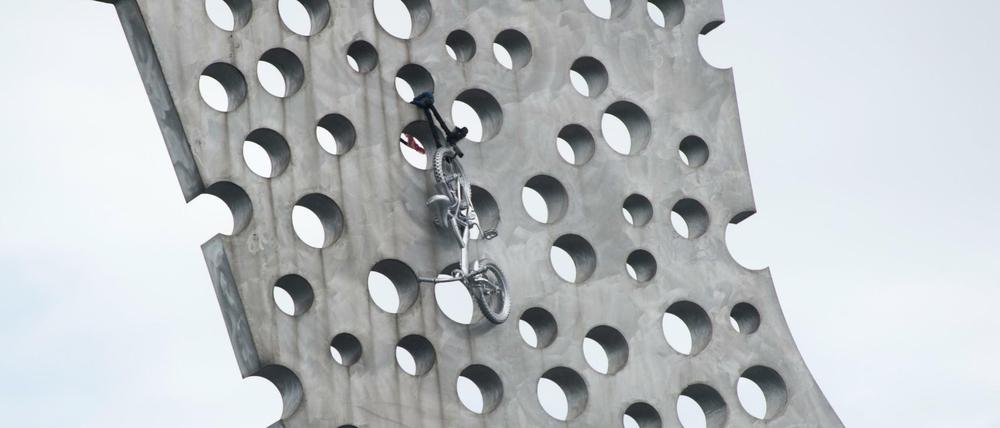 Ein Fahrrad hängt an der Skulptur "Molecule Man" des US-amerikanischen Künstlers Jonathan Borofsky.