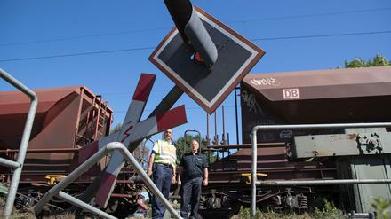Einsatzkräfte blicken am 24.08.2016 in Melle bei Osnabrück (Niedersachsen) auf eine Unfallstelle an einem Bahnübergang, an der zuvor ein Bus mit einem Güterzug verunglückt ist. Der lange Gelenkbus stand mit seinem hinteren Teil auf den Schienen, als sich die Schranken schlossen. Beim Zusammenstoß mit dem Güterzug sind mindestens neun Menschen verletzt worden. Foto: Friso Gentsch/dpa +++(c) dpa - Bildfunk+++