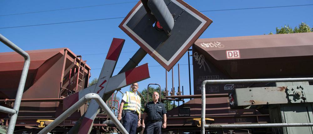 Einsatzkräfte blicken am 24.08.2016 in Melle bei Osnabrück (Niedersachsen) auf eine Unfallstelle an einem Bahnübergang, an der zuvor ein Bus mit einem Güterzug verunglückt ist. Der lange Gelenkbus stand mit seinem hinteren Teil auf den Schienen, als sich die Schranken schlossen. Beim Zusammenstoß mit dem Güterzug sind mindestens neun Menschen verletzt worden. Foto: Friso Gentsch/dpa +++(c) dpa - Bildfunk+++