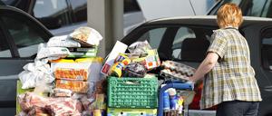 Symbolbilder Hamsterkauf Großeinkauf - Frau mit voll beladenem Einkaufswagen an ihrem Auto vor einem Großverbrauchermarkt in GothaSymbol Pictures Hamster purchase Wholesale purchasing Woman with full laden Cart to her Car before a Large consumer market in Gotha