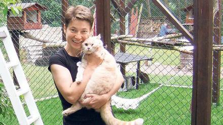 Gut aufgehoben. Heike Höhne, Betreiberin der Katzenpension Fidele in Seddin, mit einem ihrer Schützlinge. Mehr als 20 Katzen tummeln sich auf dem Gelände, in den Sommerferien muss sie viele Interessenten abweisen. 