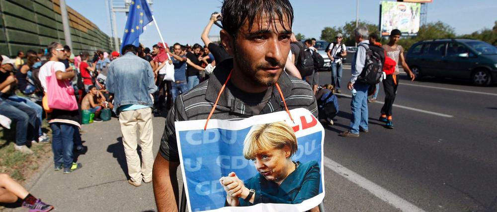 Ein Bild aus vergangenen Zeiten. In Budapest hat sich ein Flüchtling ein Bild von Merkel um den Hals gebunden.