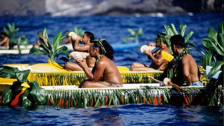 Polynesier mit Muschelhörnern in geschmückten Auslegerkanus anlässlich eines Inselfestes auf Nuku Hiva.