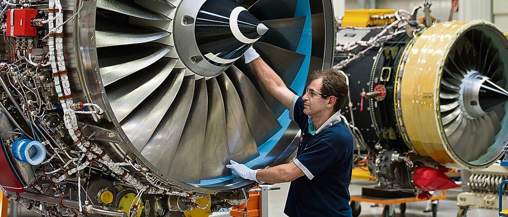 Ein Mechaniker des britischen Triebwerksherstellers Rolls-Royce arbeitet an einem Flugzeugtriebwerk im Werk in Dahlewitz am südlichen Berliner Autobahnring. Mitarbeiter werden mit Sorge nach China blicken, wo sich neue Konkurrenz formiert.