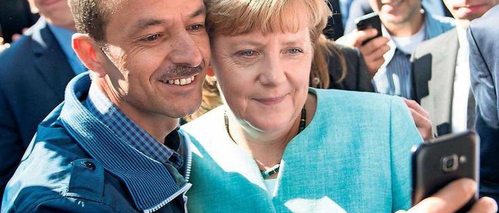 10. September 2015: Bei ihrem Besuch an der Außenstelle des BAMF am Askanierring in Spandau machen einige Flüchtlinge Selfies mit Angela Merkel. Der Autor dieses Selfies, der Iraker Schakir Kedida, äußert sich seitdem immer wieder zur Kanzlerin: Bis heute positiv.