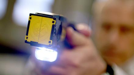 Ein sogenannter Taser wird am 18.11.2013 auf dem Gelände der Landespolizeischule in Berlin im Rahmen einer Sitzung des Innenausschusses des Berliner Abgeordnetenhauses präsentiert.