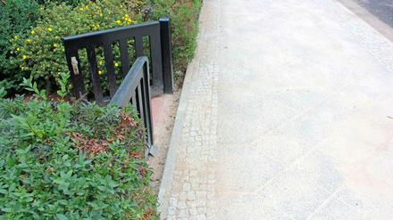 Vor den Gartentoren gibt es plötzlich eine Bordsteinkante.