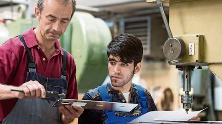 Ausbilder Wolfgang Wonneberger (l) von der Jenaer Feinblech GmbH in Jena (Thüringen) mit dem 19-jährigen Flüchtling Rezwan Waziri aus Afghanistan.