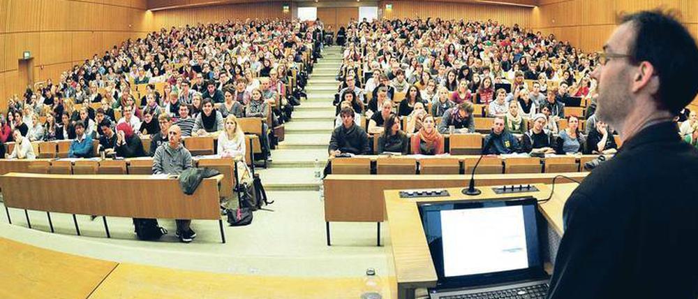 Ein Dozent steht in einem Hörsaal vor Studierenden.