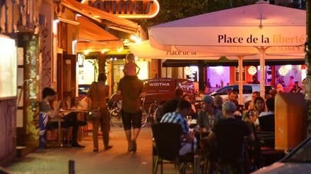Menschen sitzen in der Simon-Dach-Straße Ecke Boxhagener Straße in Berlin-Friedrichshain in Gaststätten. 