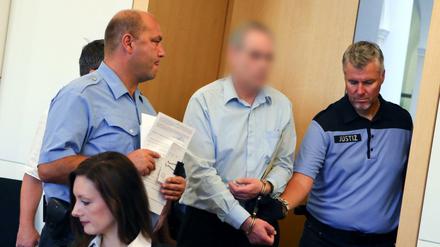 Einer der beiden am Montag verurteilten Täter (Mitte) im Fall der ermordeten 17-jährigen Anneli wird in das Landgericht in Dresden geführt. 