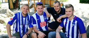 Die Fans Kevin, Martin, Felix und Nico (von links nach rechts) vom Bundesligisten Hertha BSC säubern am Aktionstag "Gemeinsame Sache" den Spielplatz am Feldstedter Weg in Berlin-Mariendorf.