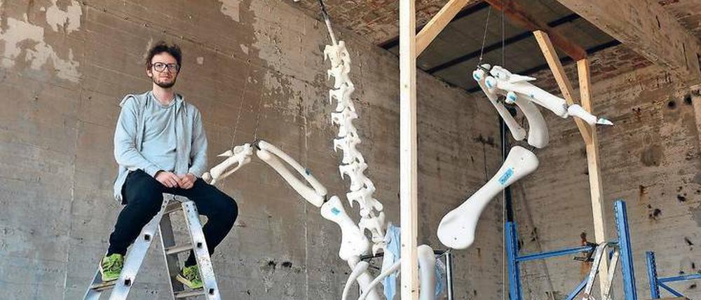 Andreas Greiner im Atelier vor dem vergrößerten Knochenmodell seines Masthahns Heinrich.