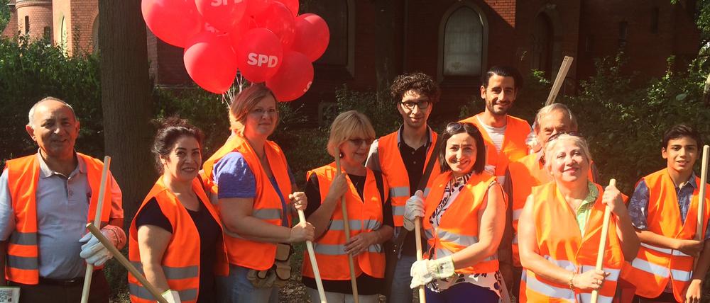 Unter dem Motto „Rot pflegt Grün“ verschönert Dilek Kolat mit Parteikollegen und Freiwilligen die Liegewiese hinter der Nathanael-Kirche.