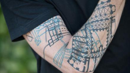 Architekt Joachim Träuptmann präsentiert sein Unterarm-Tattoo. 