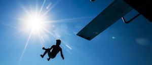 Sprung in den Herbst. Abkühlung verschafft ein Bad im Wasser.