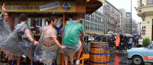 Berlin-Touristen auf dem Bierbike beim Sightseeing am Checkpoint Charlie an der Friedrichstraße in Berlin.