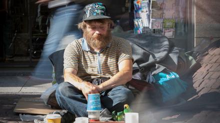 Der als "Eisenbahn-Reiner" in der Frankfurter Obdachlosen-Szene bekannte Reiner Schaad sitzt auf seinem Stammplatz in der Innenstadt von Frankfurt am Main (Hessen), während Passanten an ihm vorbei hetzen.