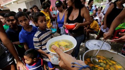 Kinder aus armen Familien stehen in den Suppenküchen von Caracas Schlange. 