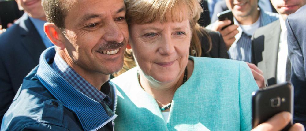 Bundeskanzlerin Angela Merkel (CDU) lässt sich im Herbst 2015 mit einem Flüchtling fotografieren.