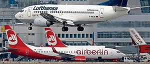 Eine Boeing 737 der Lufthansa am Flughafen Düsseldorf - wo Air Berlin ein Drehkreuz betreibt. Im Hintergrund stehen Flugzeuge der Fluggesellschaft Air Berlin.
