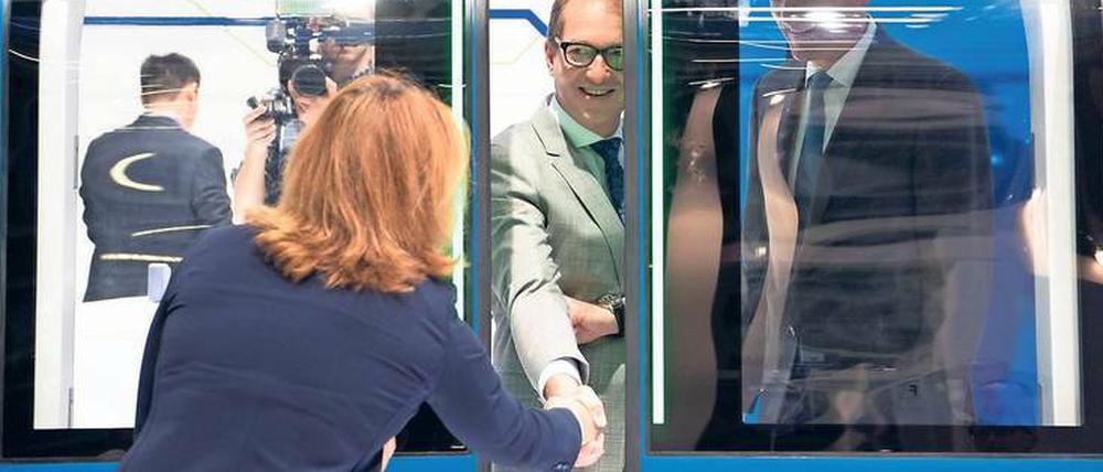 Auf und zu. Verkehrsminister Dobrindt probiert während des Innotrans-Rundgangs am Stand von Knorr Bremse das Öffnen und Schließen einer Tür für U-Bahnen aus.