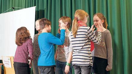 "Gefühle erkennen": Grundschulkinder bei einer Übung aus dem Fairplayer-Manual.