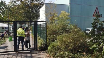 Ein Mitarbeiter eines Sicherheitsdienstes bewacht in Köln Porz den Zugang zu einer als Flüchtlingsunterkunft genutzten Turnhalle. Hier wurde ein 16-Jähriger Syrer festgenommen.