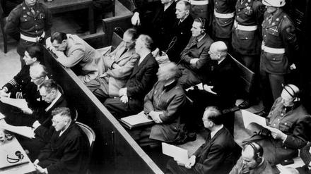 Die Angeklagten im Kriegsverbrecher-Hauptprozess: In der zweiten Reihe sitzen (v.l.) Hermann Göring, Rudolf Hess, Joachim von Ribbentrop, Wilhelm Keitel, Alfred Rosenberg und Hans Frank. In der hinteren Reihe sind (von links) die Angeklagten Karl Dönitz, Erich Räder, Baldur von Schirach, Fritz Sauckel und Alfred Jodl zu sehen. Die Verteidiger sitzen vor den Angeklagten.