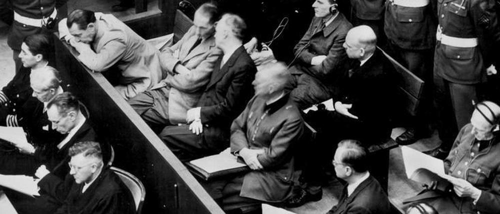 Die Angeklagten im Kriegsverbrecher-Hauptprozess: In der zweiten Reihe sitzen (v.l.) Hermann Göring, Rudolf Hess, Joachim von Ribbentrop, Wilhelm Keitel, Alfred Rosenberg und Hans Frank. In der hinteren Reihe sind (von links) die Angeklagten Karl Dönitz, Erich Räder, Baldur von Schirach, Fritz Sauckel und Alfred Jodl zu sehen. Die Verteidiger sitzen vor den Angeklagten.