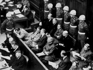 Die Angeklagten im Kriegsverbrecher-Hauptprozess: In der zweiten Reihe sitzen (v.l.) Hermann Göring, Rudolf Hess, Joachim von Ribbentrop, Wilhelm Keitel, Alfred Rosenberg und Hans Frank. In der hinteren Reihe sind (von links) die Angeklagten Karl Dönitz, Erich Räder, Baldur von Schirach, Fritz Sauckel und Alfred Jodl zu sehen. Die Verteidiger sitzen vor den Angeklagten.