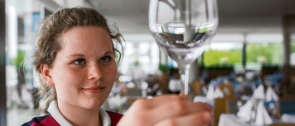 Eine Schülerin macht ein Praktikum in einem Restaurant. 