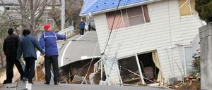 Einwohner begutachten nach der Atomkatastrophe in Fukushima ihre zerstörten Häuser. 