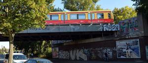 Eine S-Bahn fährt in der Schorfheidestraße nahe dem S-Bahnhof Wilhelmsruh in Berlin über eine Bahnbrücke mit Graffitis. Hier starben zwei junge Männer.