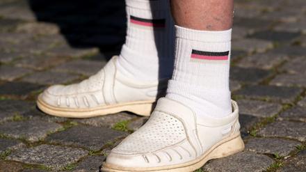 Nicht schön. Ein Anhänger der islamfeindlichen Pegida-Bewegung trägt weiße Socken mit der Flagge Deutschlands. 