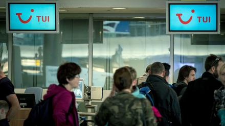 Fluggäste stehen am Dienstag vor dem Abflugschalter der Tuifly auf dem Flughafen in Hannover.