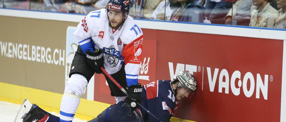 Eisbären-Spieler Spencer Machacek landet nach einem Rempler mit Robin Grossmann an der Bande. Foto Juergen Engler