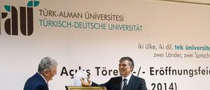 Zwei Männer enthüllen eine Gedenktafel.