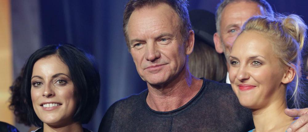 Der britische Sänger und Rockmusiker Sting steht bei der Verleihung des Deutschen Radiopreises am Ende der Sendung mit Silbermond-Sängerin Stefanie Kloß (l) und der Moderatorin Carolin Kuhn vom Berliner Spreeradio auf der Bühne.
