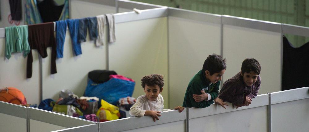 Kinder in einem Hangar im ehemaligen Flughafen Tempelhof sind an den Stellwänden der Familienunterkünfte hochgeklettert.