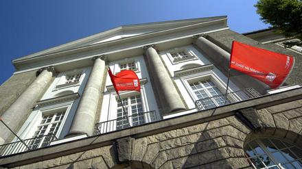 Fassade eines Universitätsgebäudes mit roten Fahnen und Aufschrift Universität der Künste.
