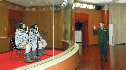 Macht’s gut. Fast beiläufig grüßt ein hoher Militärangehöriger die beiden Astronauten Jing Haipeng und Chen Dong, die keimfrei abgeschirmt auf eine Besprechung warten, in der sie letzte Instruktionen bekommen, was sie im All tun sollen.
